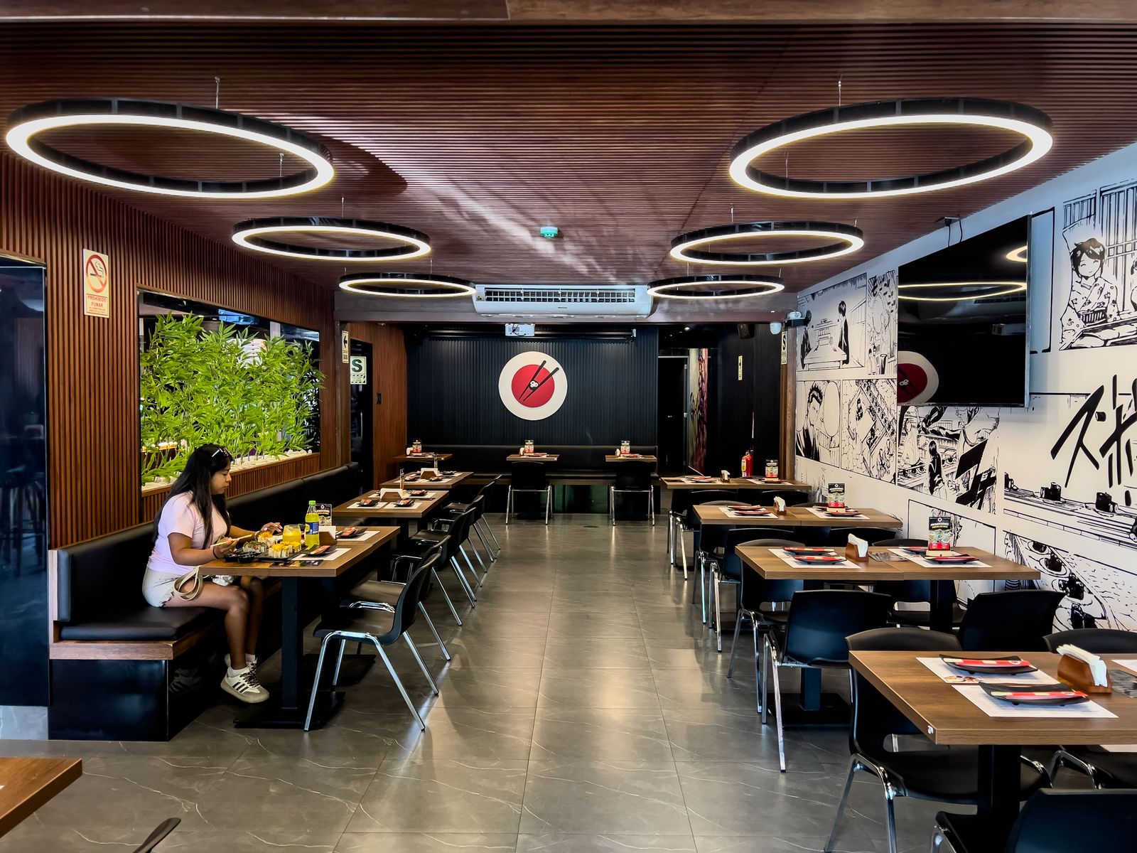 Comedor principal de OHASHI Los Olivos con techo de listones de madera y anillos de luz
